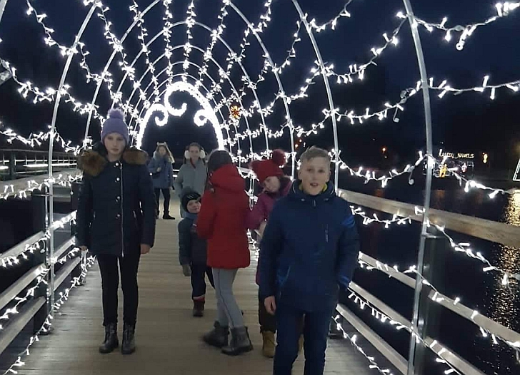 Ant šventiškai išpuošto pėsčiųjų tilto.