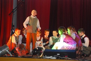 Gelvonų vidurinės mokyklos vaikų folklorinio ansamblio „Dagilėlis“ vaikai klausosi pasakojimo apie melagį.