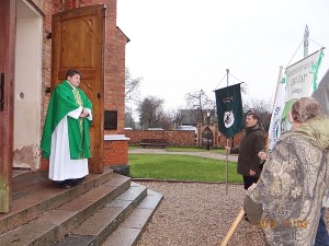 Prie bažnyčios eiseną su vėliavomis sutiko kunigas Virgilijus Balnys.