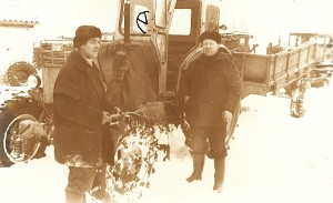 Vladas Meškerevičius (kairėje) ir Jonas Šmigelskas visą gyvenimą dirbo kolūkyje, vairavo ne tik įvairius traktorius, bet ir kombainus. Už jo - sovietinis Lipecko gamybos traktorius T-40 su oru aušinamu varikliu. Anuomet kartais jie būdavo pavadinami „sausajėgiais“, „katinais“. Tolumoje - Charkovo traktorių gamykloje pagamintas vikšrinis traktorius T-74.