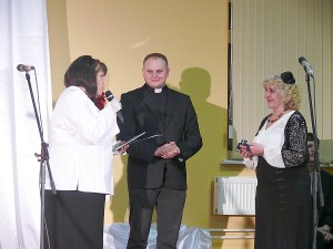 Molėtų vikaras Mindaugas Grenda (centre) įteikia nominaciją „Metų saviveiklininkė“ Elenai Lekavičienei (dešinėje).