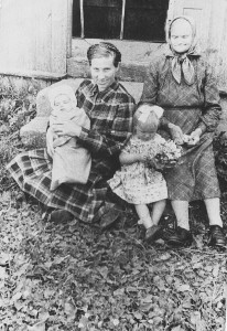 1958 metų liepos 7 diena. Su gėlėmis 1,5 metukų Rita Bilotaitė - Tonkevičienė, mama Elena Bilotienė laiko ant rankų brolį Robertą Bilotą ir močiutė Marijona Bilotienė.